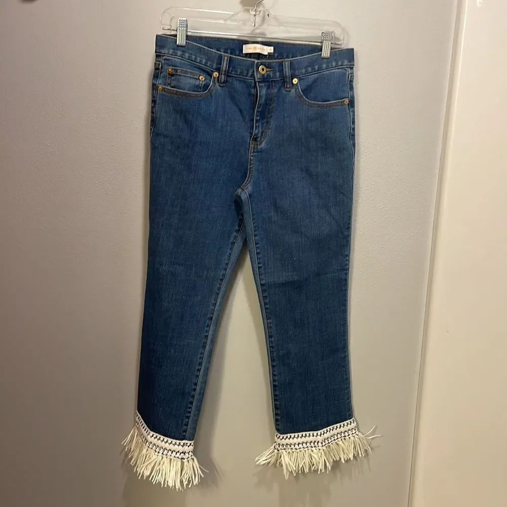 Tory Burch Connor jeans in medium allover stone wash. Cropped. Raffia fringed